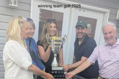 The 2025 winning team holding the trophy outside the clubhouse