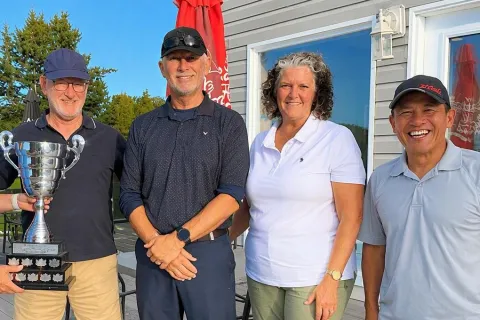 The 2026 winning team with the trophy on the clubhouse patio