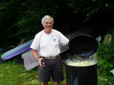 Man standing over a big pot of corn outside
