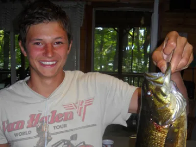 Chris holding a fish while standing in the kitchen