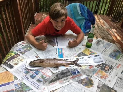 Julian Tilman leaning over the table with a 17 inch bass resting on it