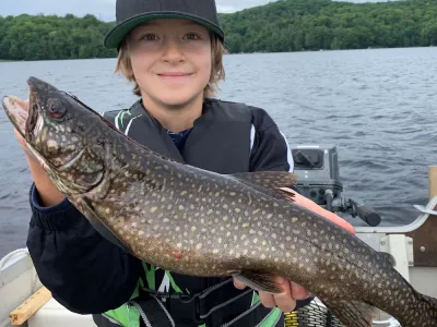 Marcello Richert holds up a Lake Trout while in a boat on Percy Lake.