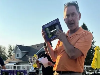 Tim holds up a prize he won for getting closest to the pin.