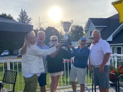 Shelley and team #1 hold up the tournament trophy in celebration.