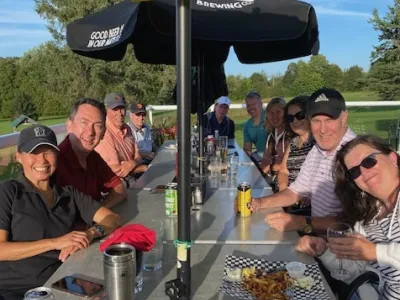 A group of golfers toast at a patio table after the tournament.