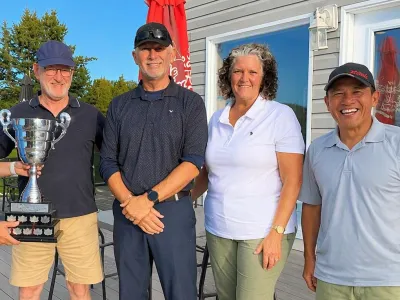The 2026 winning team with the trophy on the clubhouse patio