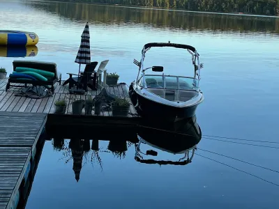The dock sections with lounge chairs and a moored boat on calm water