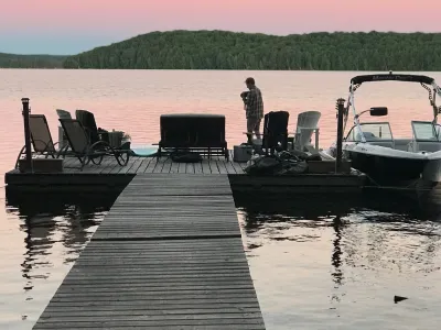 The dock and ramp at dusk with a pink sky over the lake
