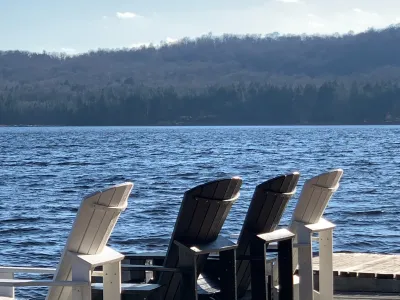Muskoka chairs lined up on the dock facing the lake